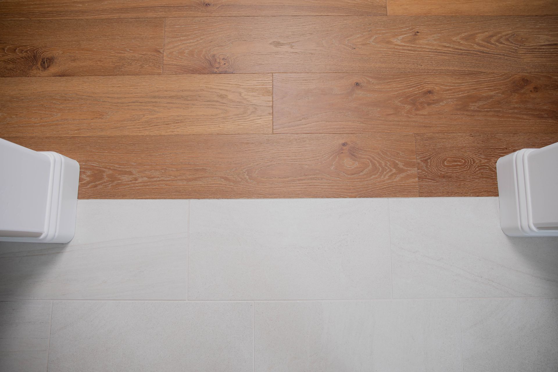 There is a wooden floor and a white wall.