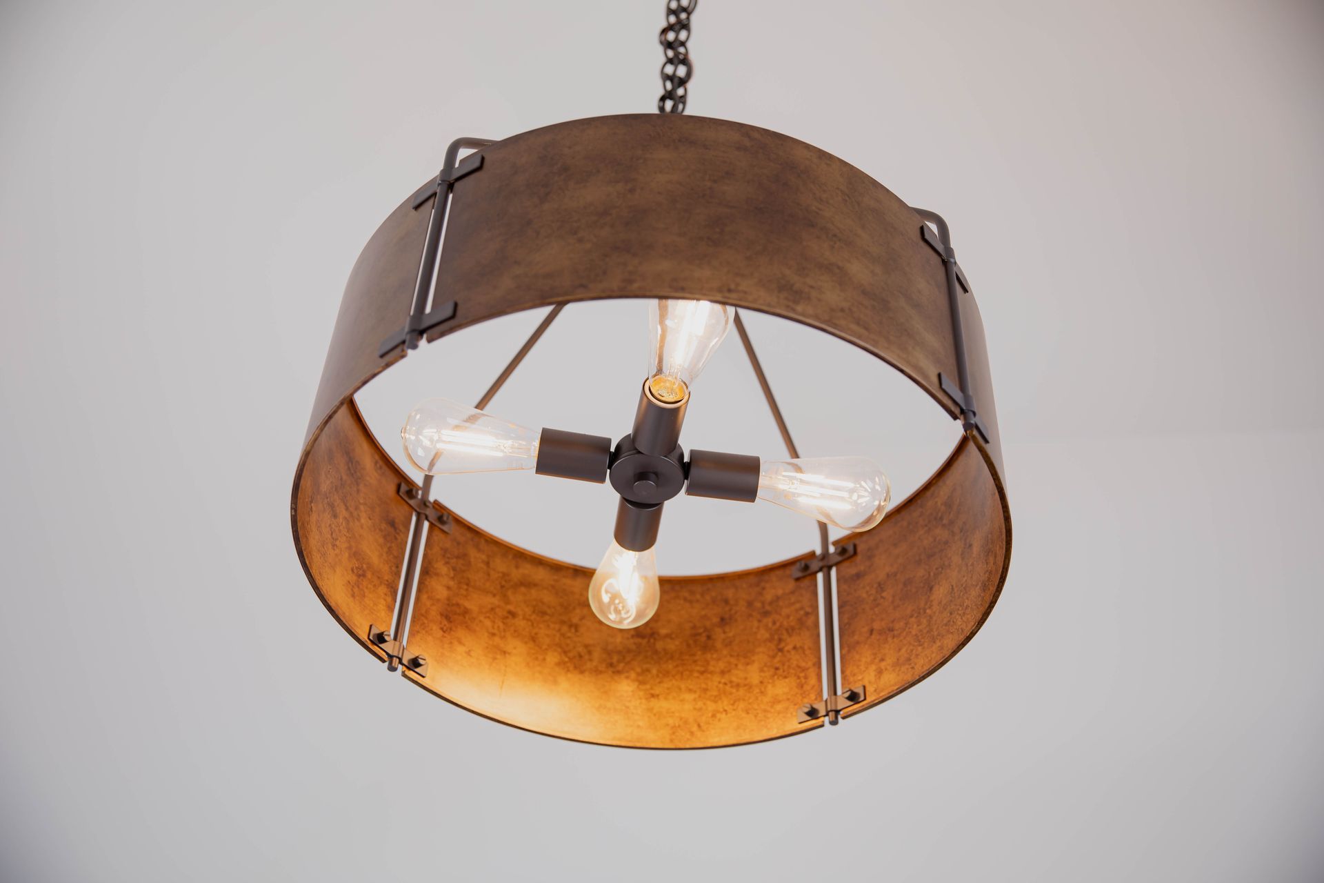 A chandelier with a light inside of it is hanging from the ceiling.