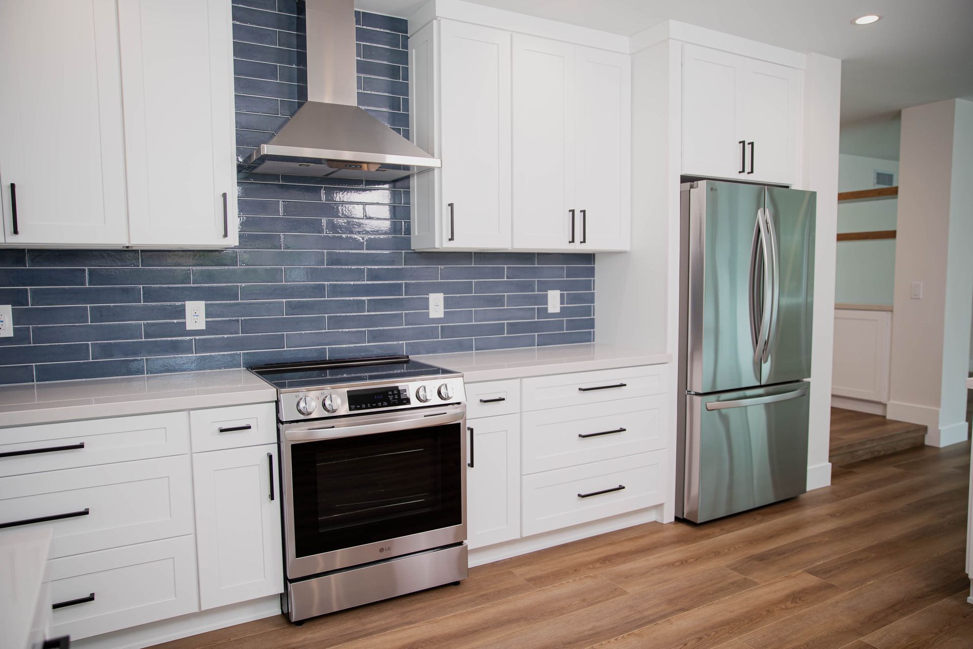 A kitchen with white cabinets and stainless steel appliances
