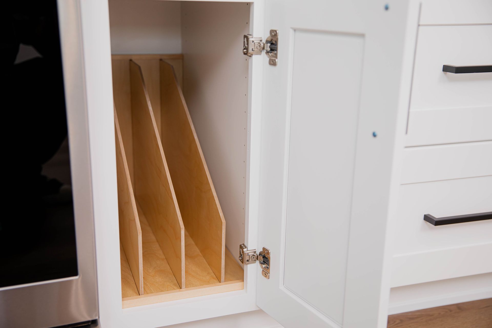 A white cabinet with a wooden divider inside of it.