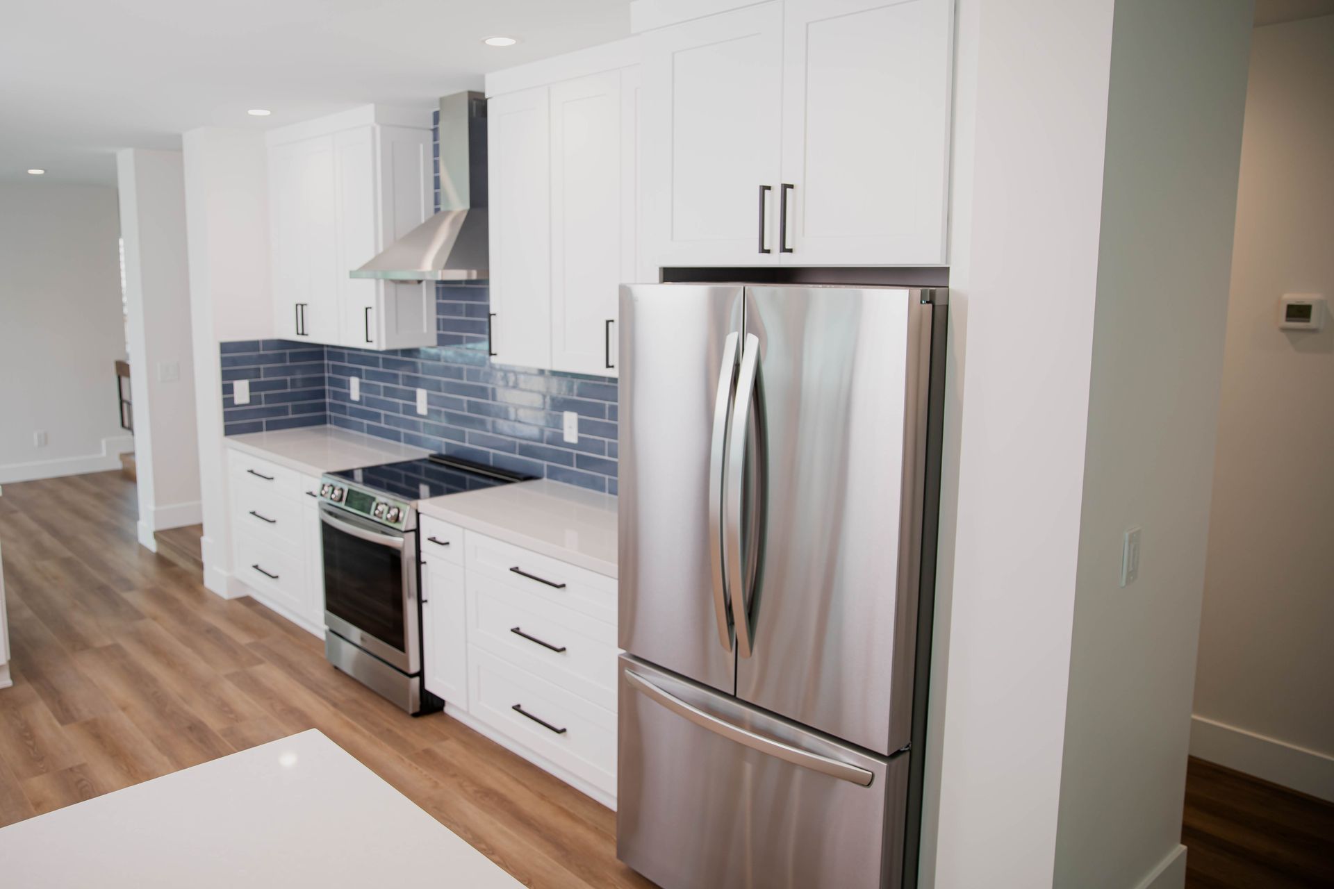 A kitchen with stainless steel appliances and white cabinets.