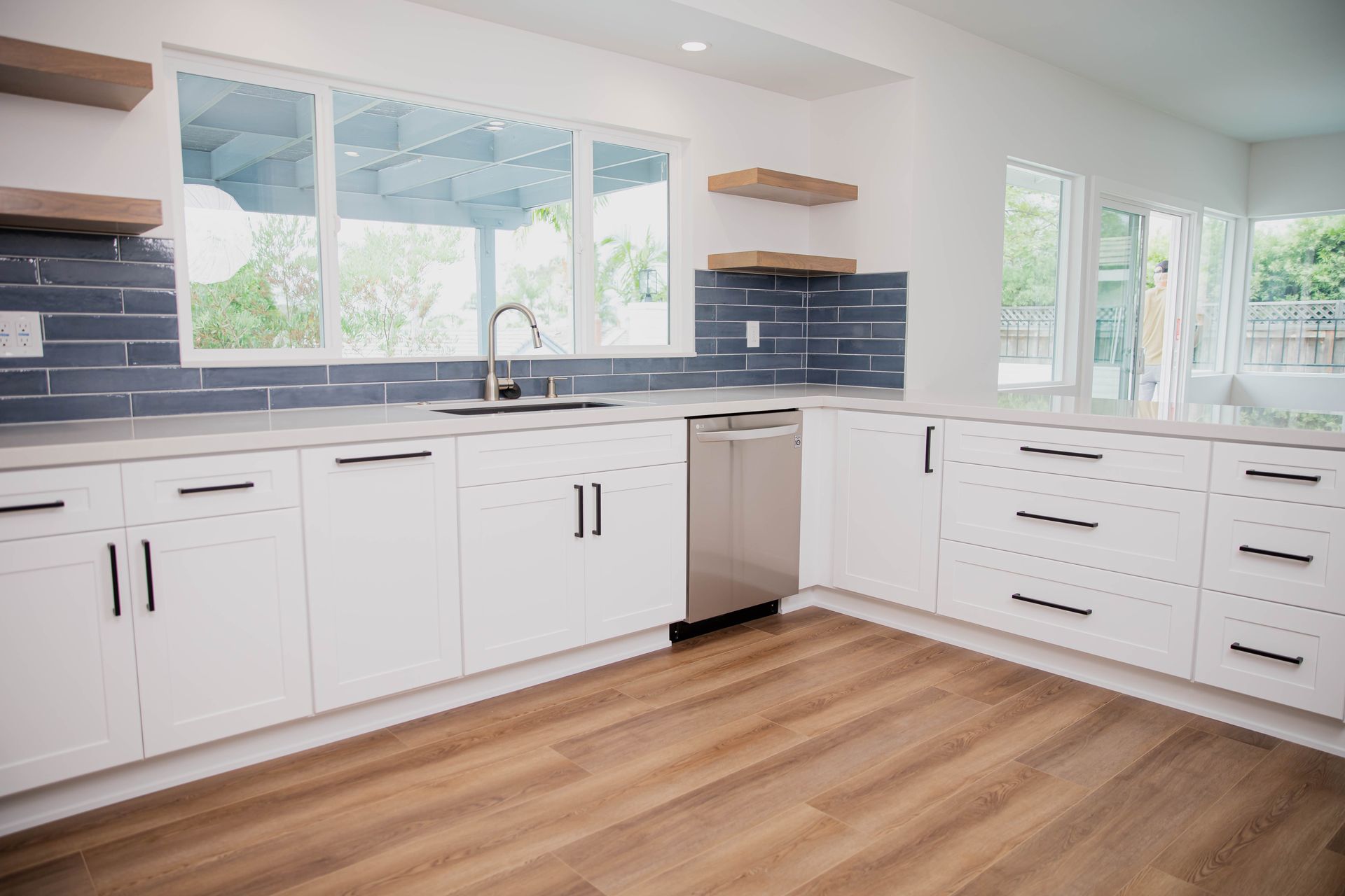 An empty kitchen with white cabinets and stainless steel appliances.