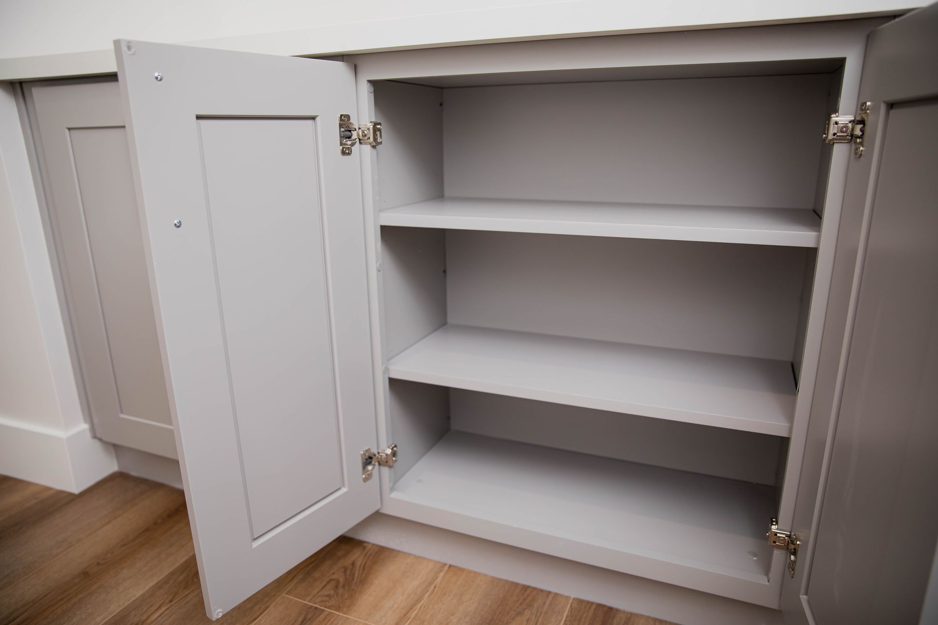 An empty cabinet with the doors open and shelves.