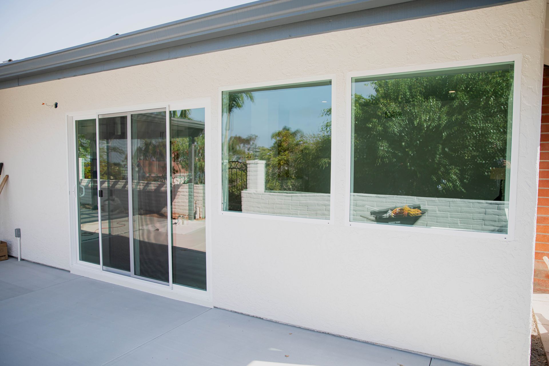 A white house with a lot of windows and sliding glass doors.