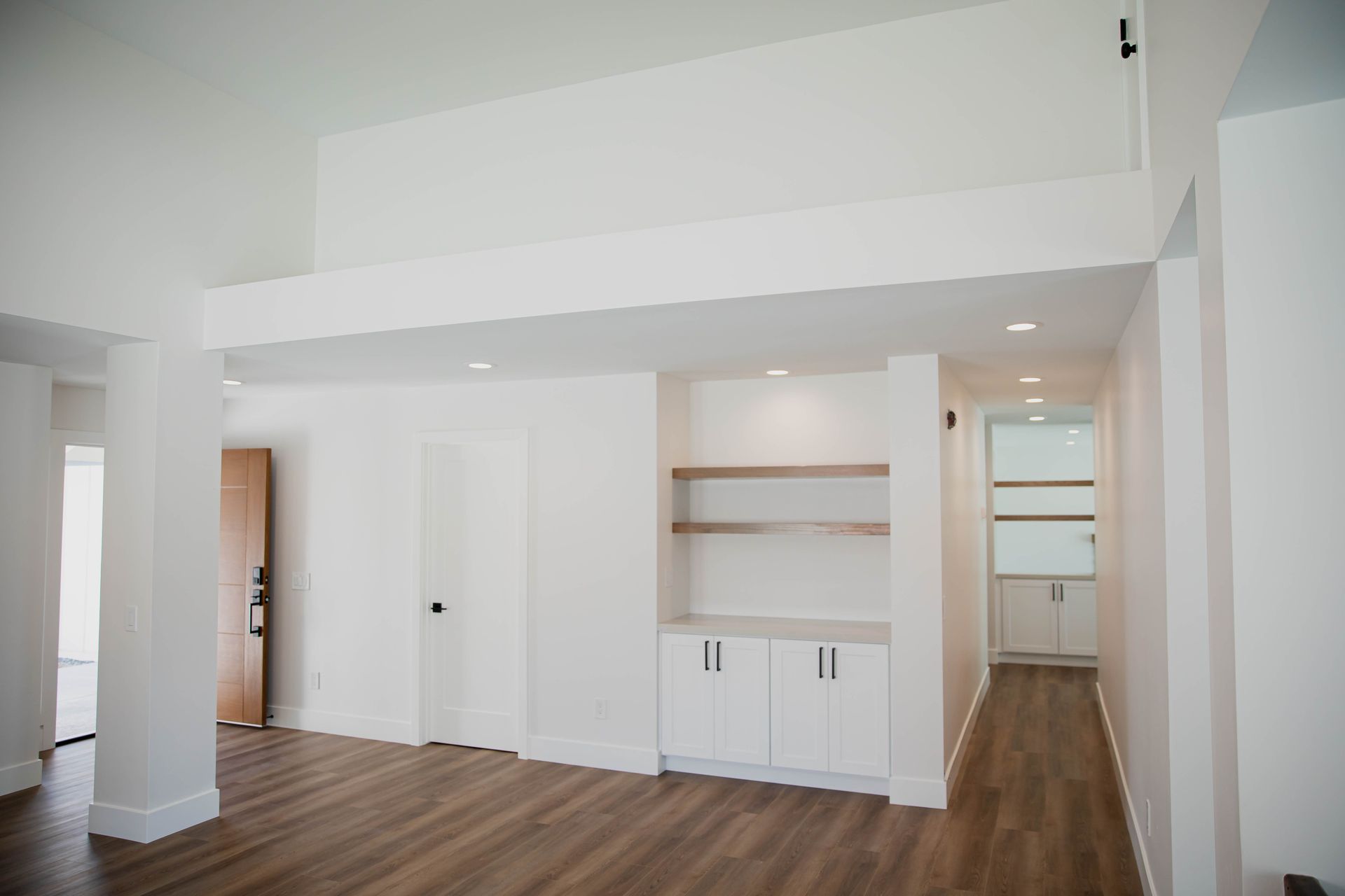 A large empty room with hardwood floors and white walls
