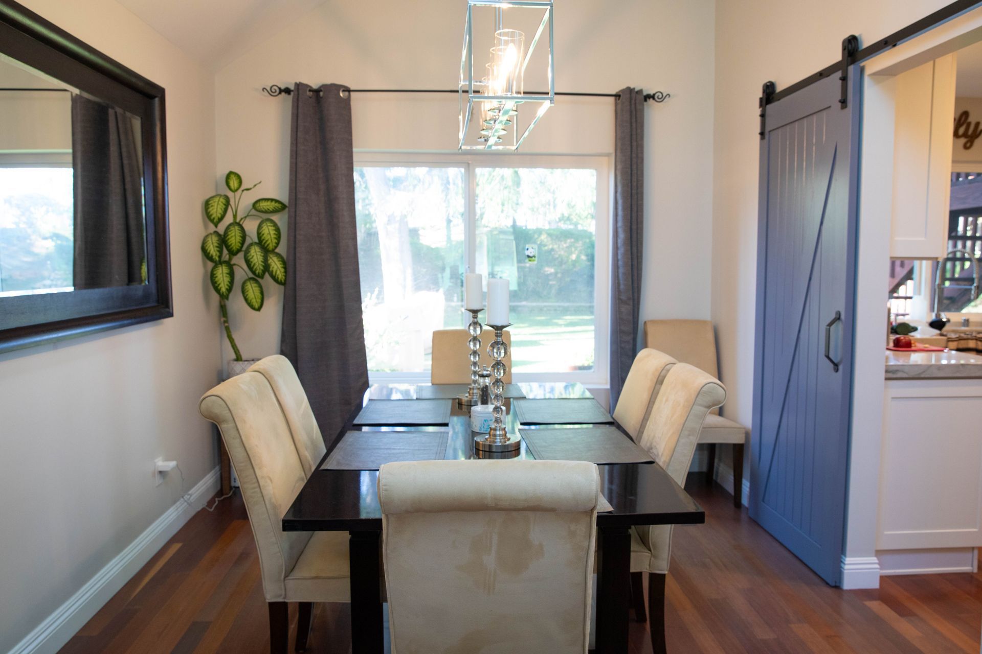 A dining room with a table and chairs and a sliding barn door