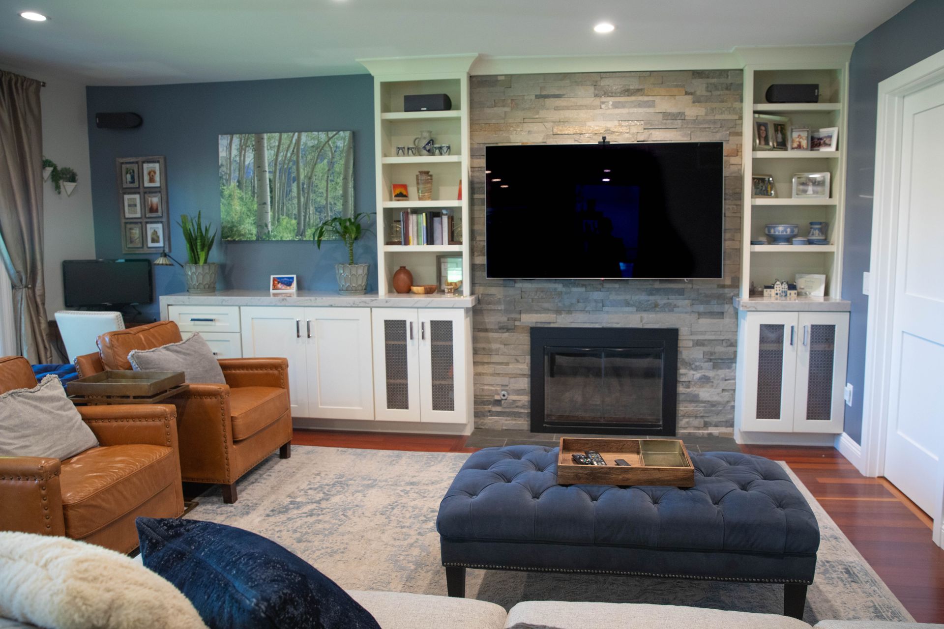 A living room with a fireplace and a flat screen tv on the wall.