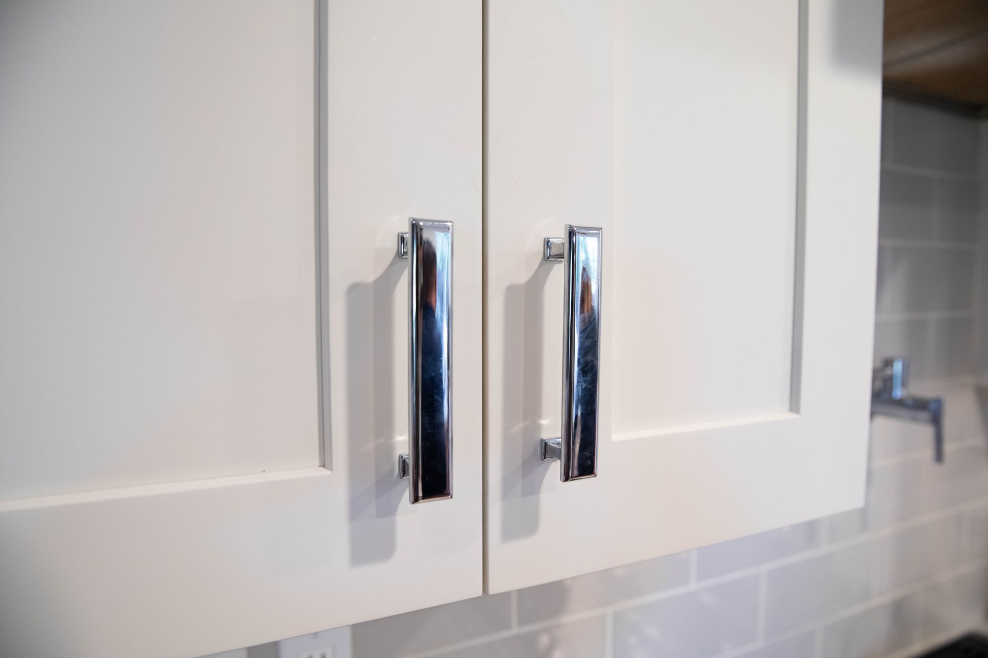 A close up of a kitchen cabinet with chrome handles.