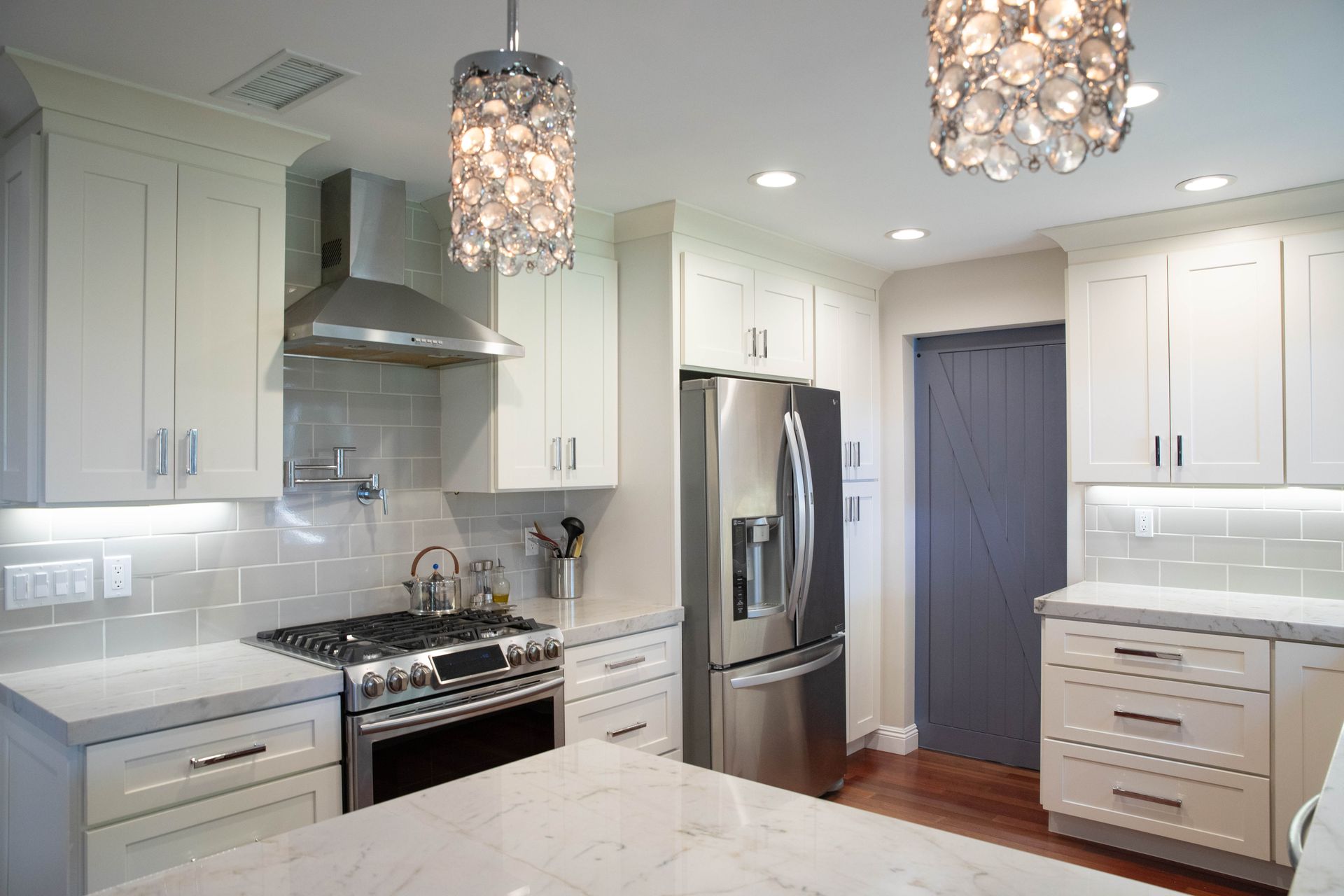 A kitchen with white cabinets and stainless steel appliances