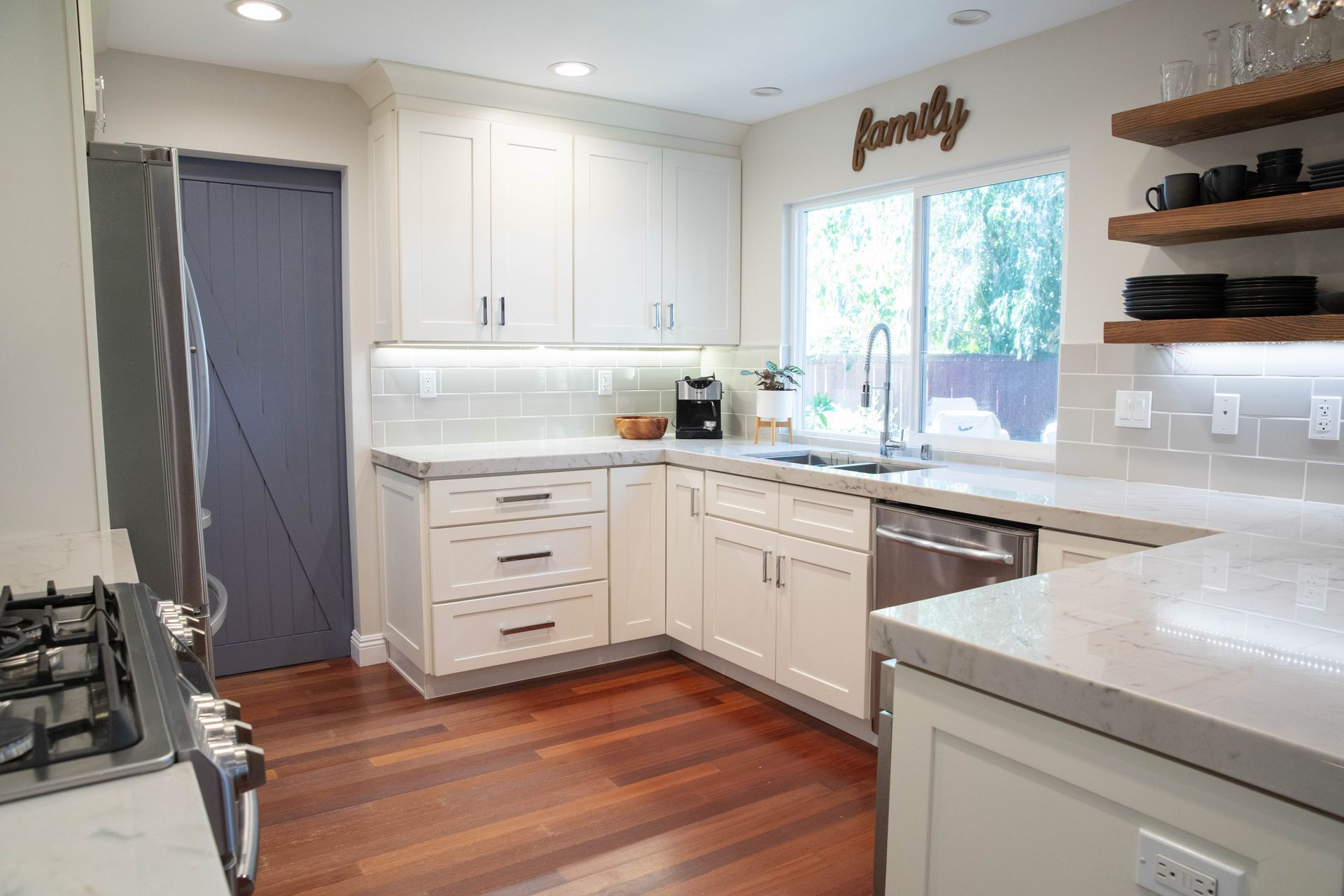 A kitchen with white cabinets and a sign that says family