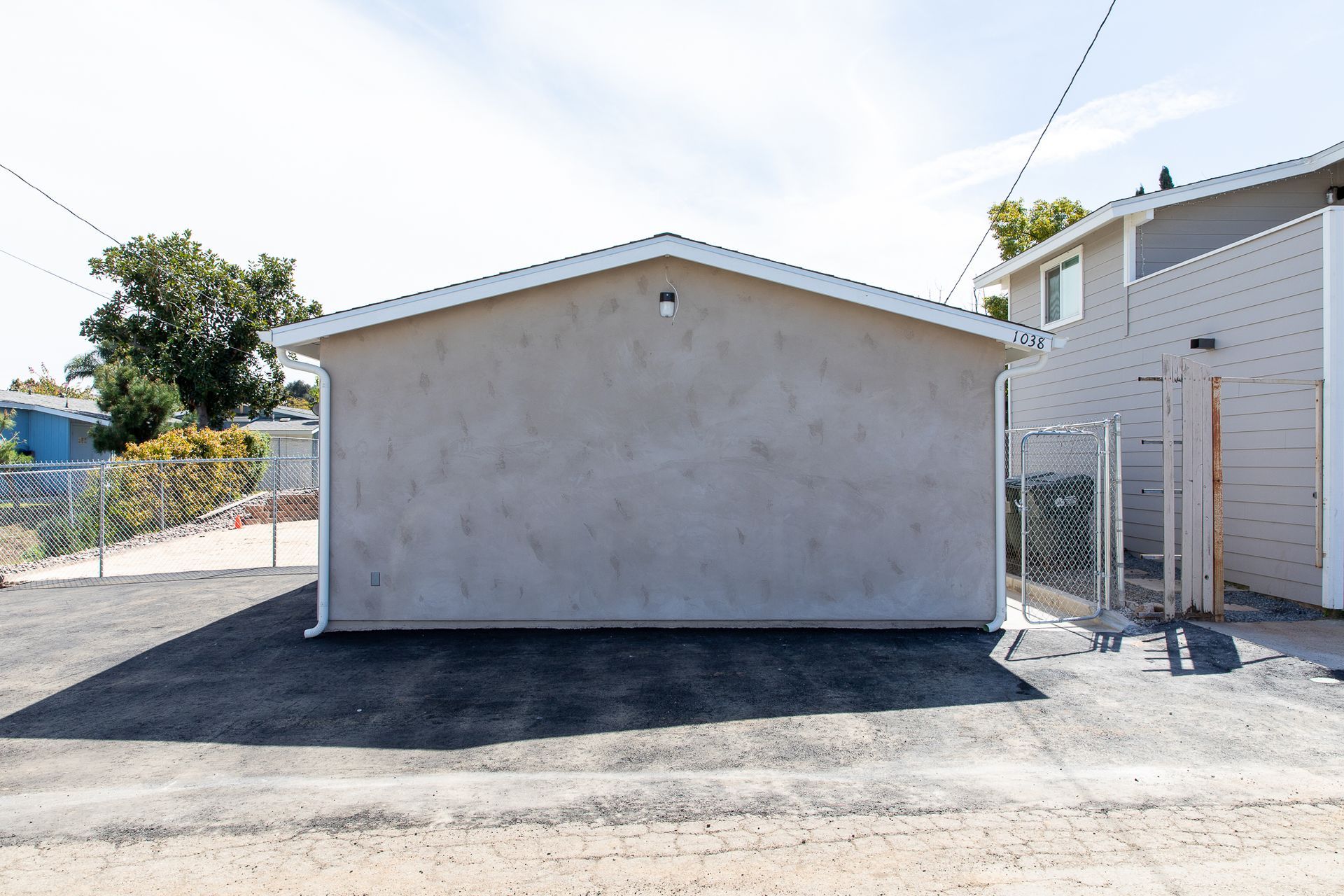 A small building with a white roof is next to a chain link fence