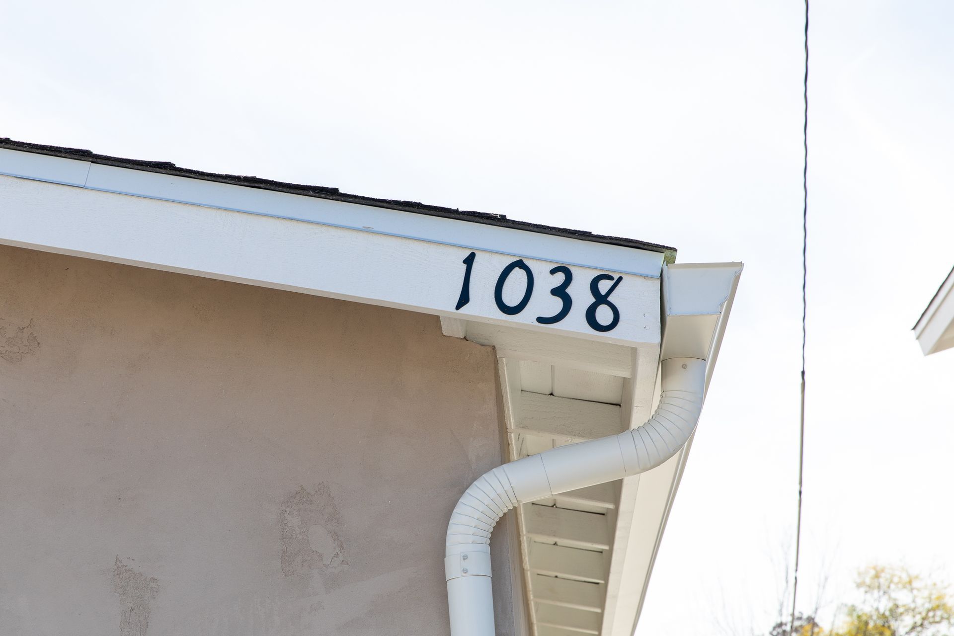 The number 1038 is painted on the side of a house