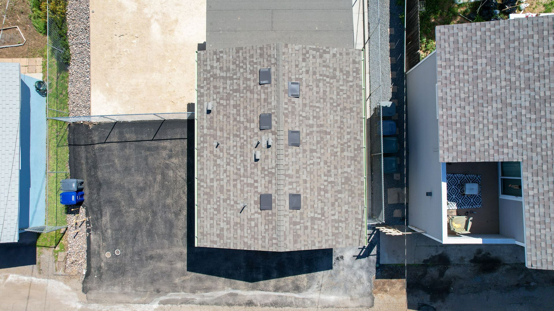 An aerial view of a house with a gray roof