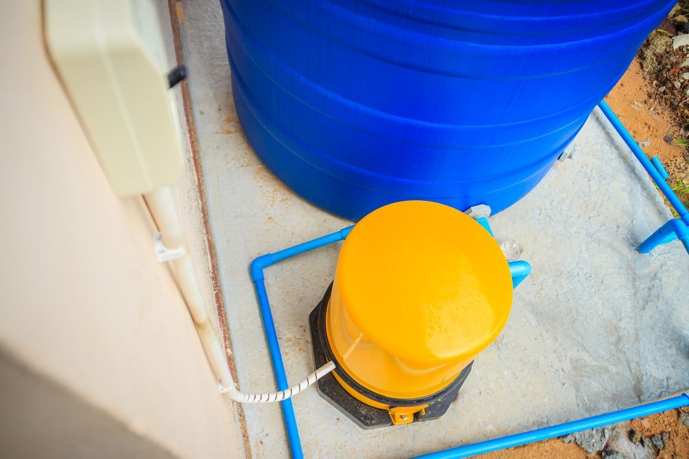 Um tanque de água azul com uma bomba amarela acoplada a ele.