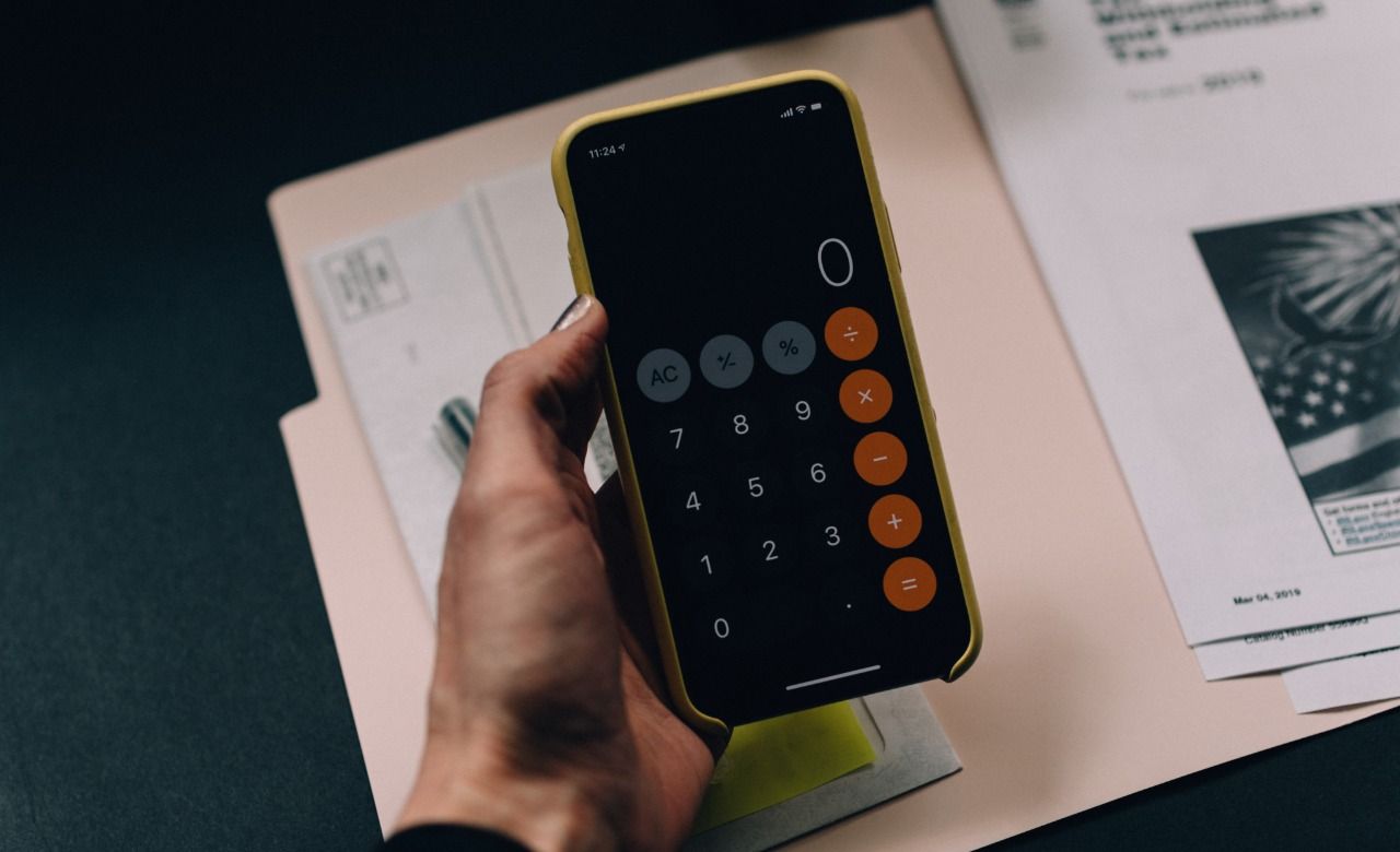 Uma pessoa está segurando um celular com uma calculadora.
