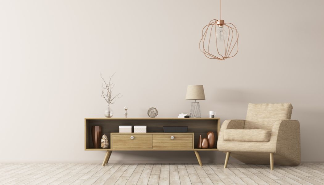 Uma sala de estar com uma cadeira, cômoda e luminária.