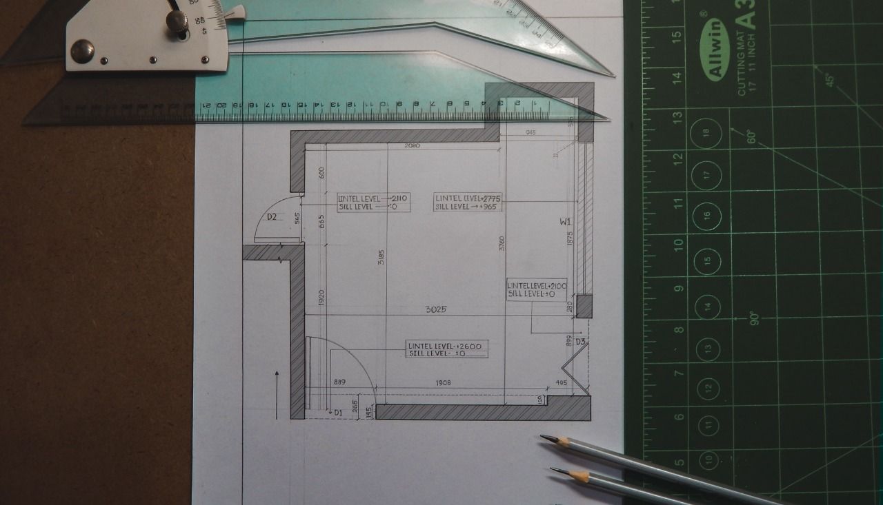 Um desenho de uma sala com uma régua e lápis sobre uma mesa.