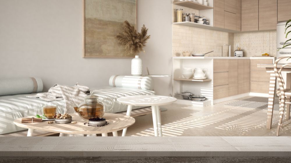 Uma sala de estar com um sofá, mesas de centro e uma cozinha.