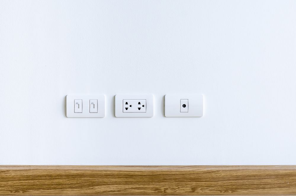Há três tomadas elétricas na parede.