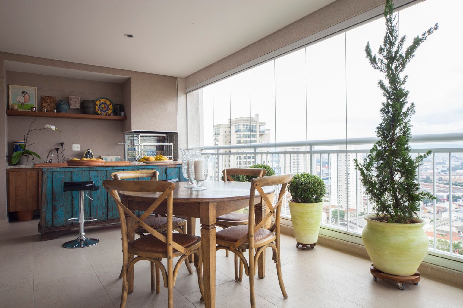 Uma varanda com mesa, cadeiras e plantas em vasos.