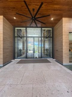 Wooden double doors with ornate glass panels, inside a house.