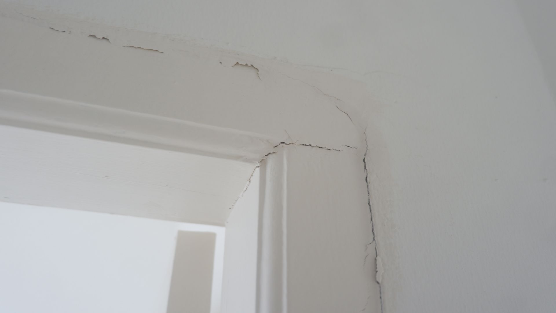 White door frame with dark specks near corner and top edge.