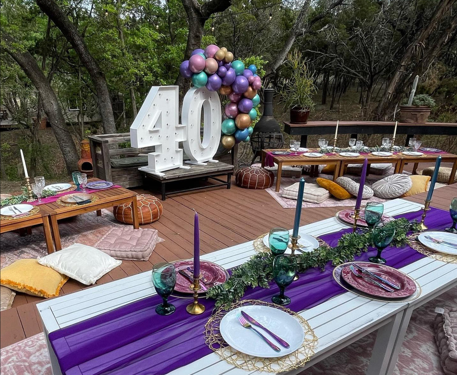 A table set for a 40th birthday party with plates , candles , and balloons.