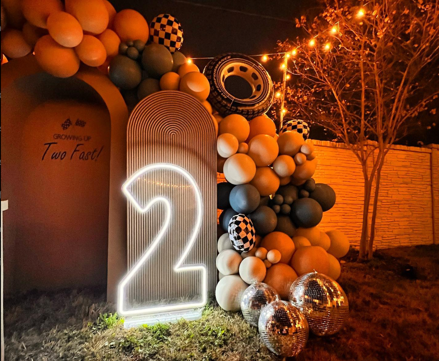 A neon sign with the number 21 on it is surrounded by balloons and lights.