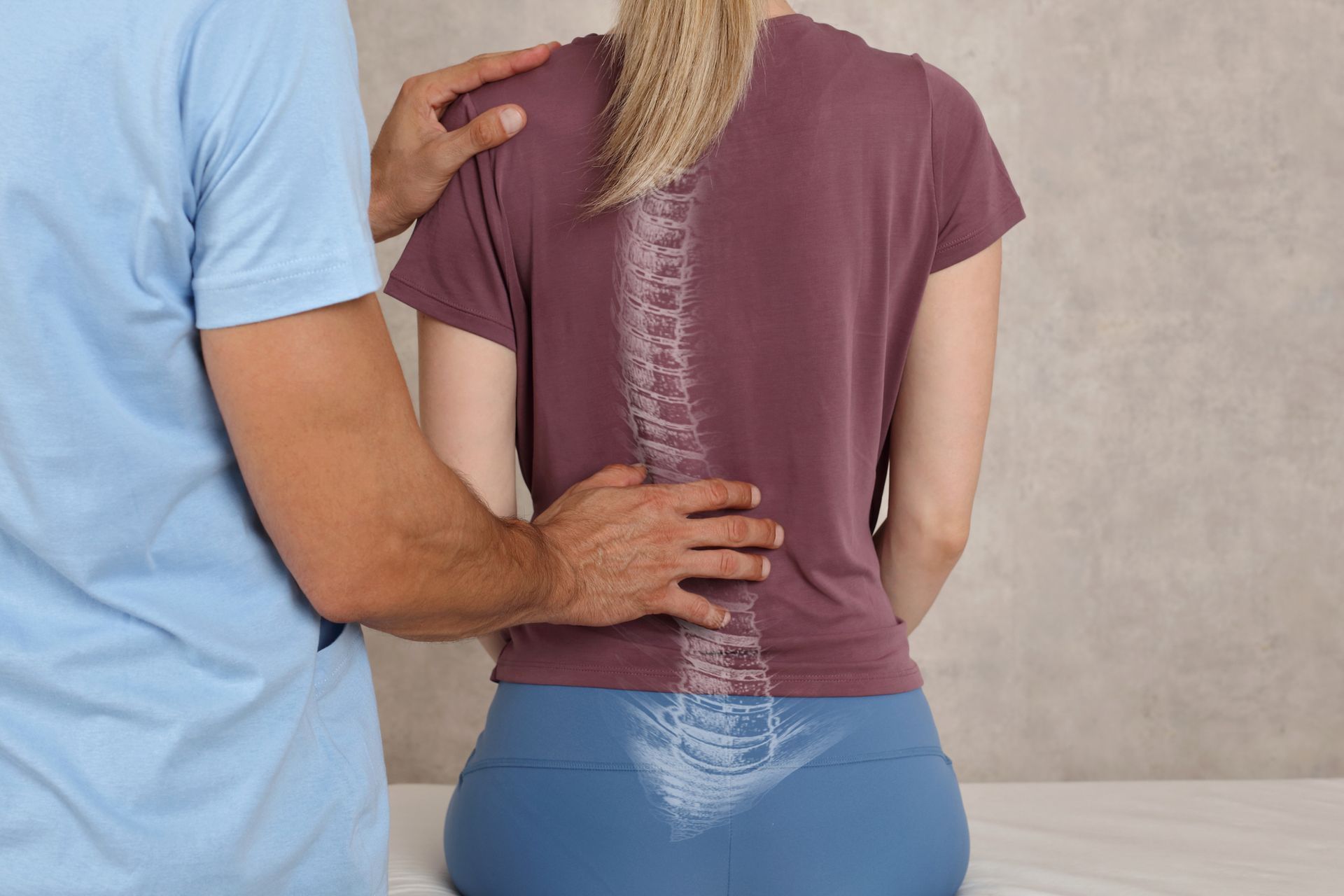 Un chiropratico sta aggiustando la schiena di una donna, con la colonna vertebrale ben visibile sulla sua maglietta.