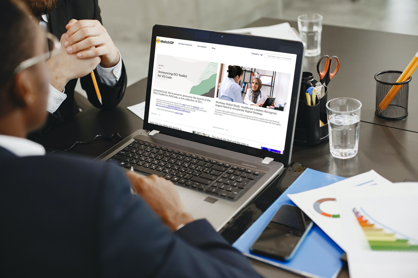 A man is sitting at a table using a laptop computer.