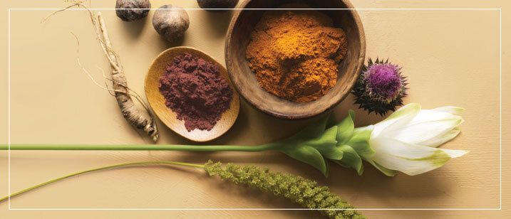 Spa setup: black stones stacked, bamboo, oil bottle, candle, towel.