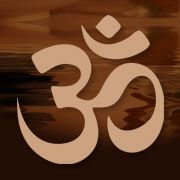 Om symbol in tan against a blurry brown and orange background.