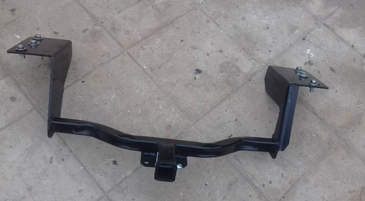 Un enganche de remolque negro está sobre un suelo de baldosas.