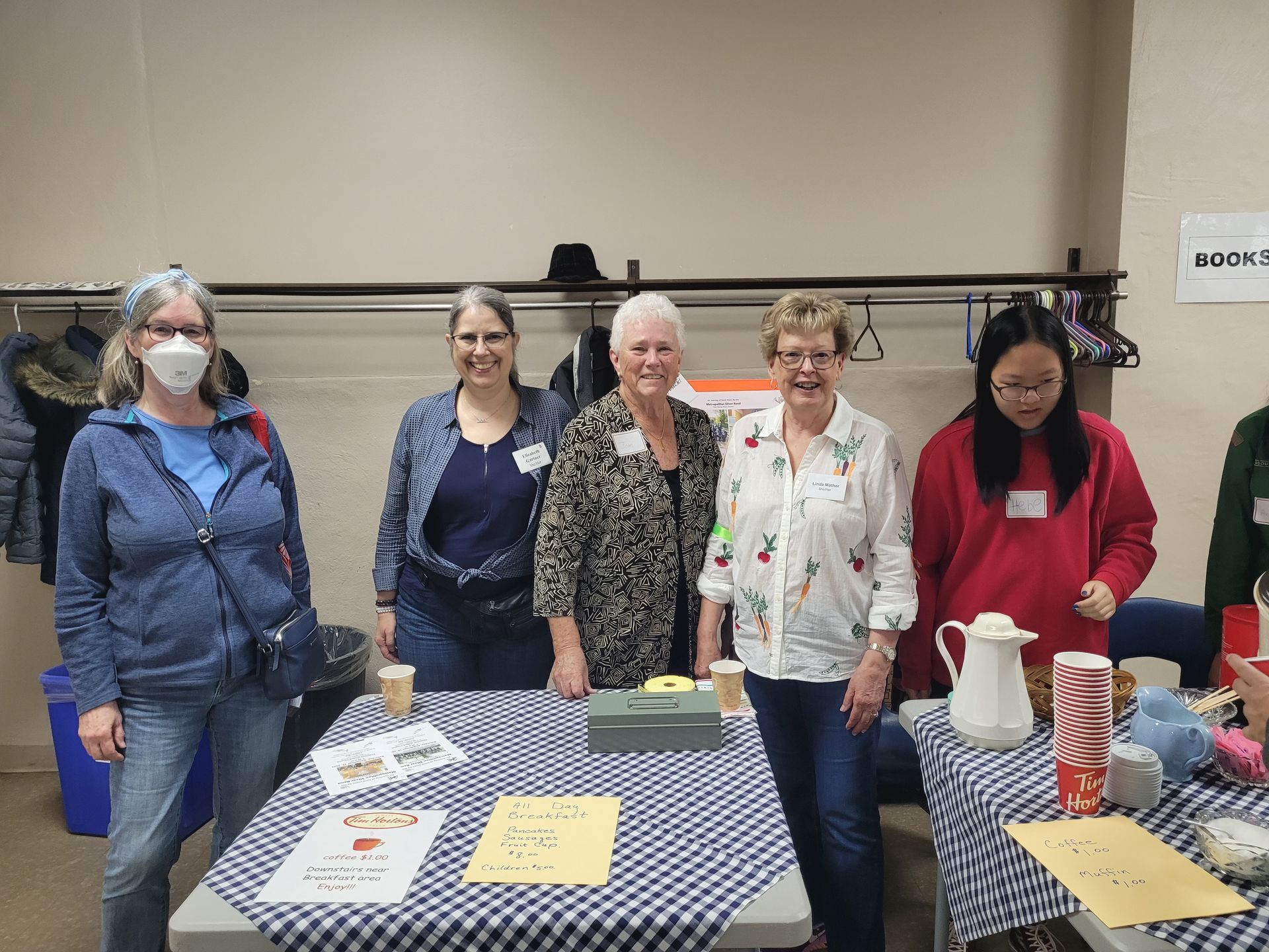 a group of women are standing around a table .