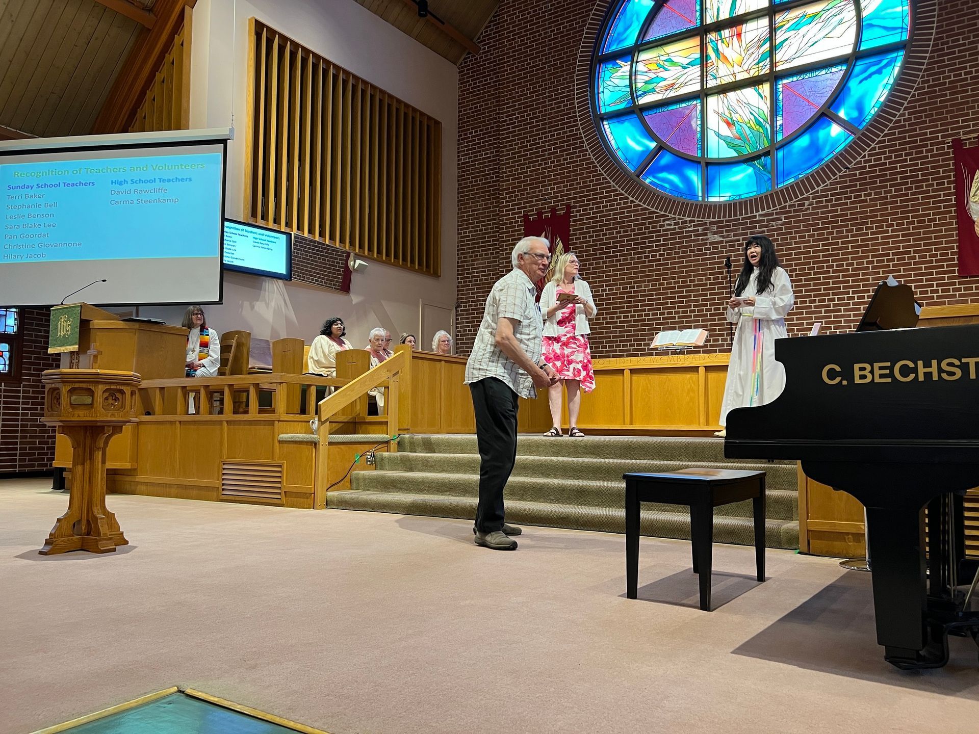 a man and a woman are standing in front of a piano in a church .