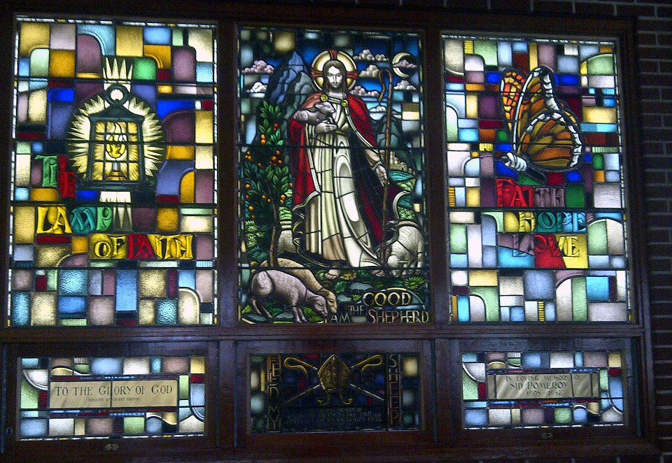 a stained glass window with jesus and a butterfly on it