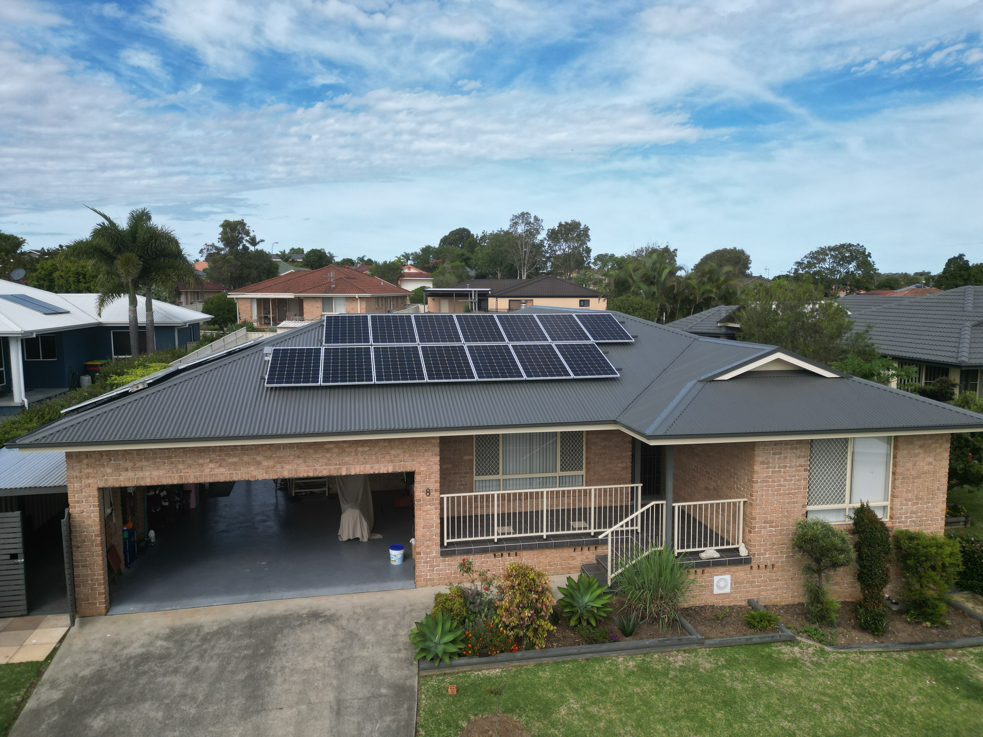 A Brick House With A White Roof And A Large Tank In Front Of It — Bulley Roof Restoration, Painting & Pressure Cleaning in Wingham, NSW