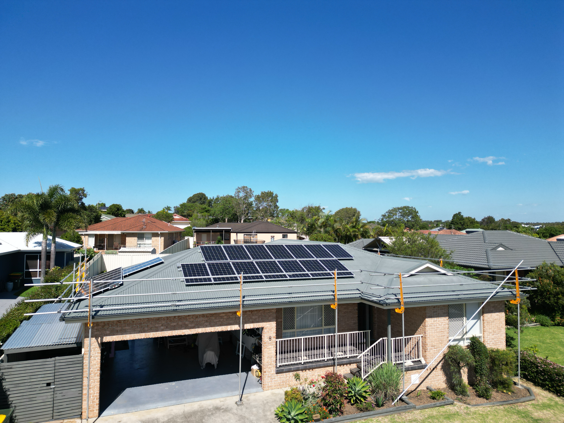 A Brick House With A Metal Roof Is Sitting On Top Of A Lush Green Field — Bulley Roof Restoration, Painting & Pressure Cleaning in Wingham, NSW