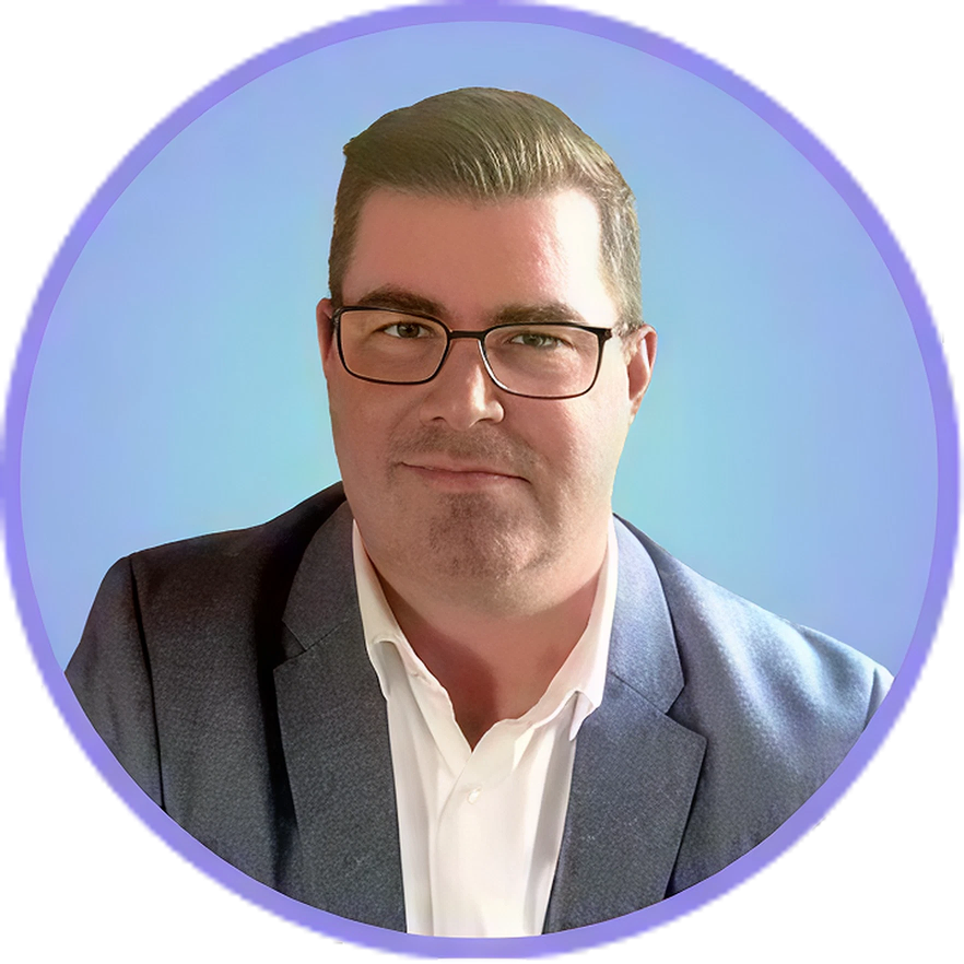 Man wearing glasses, white shirt, and a blue blazer, set against a blue background.