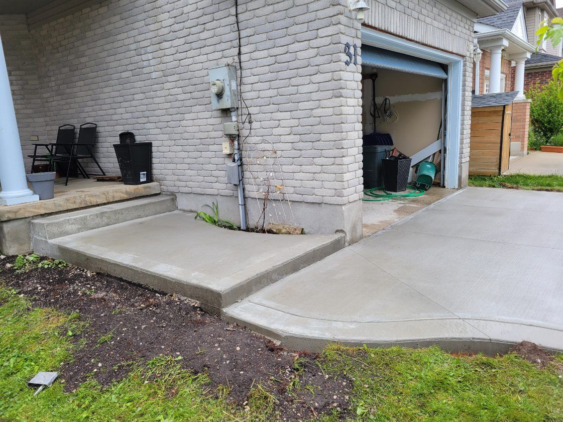 A brick house with a concrete walkway leading to a garage.