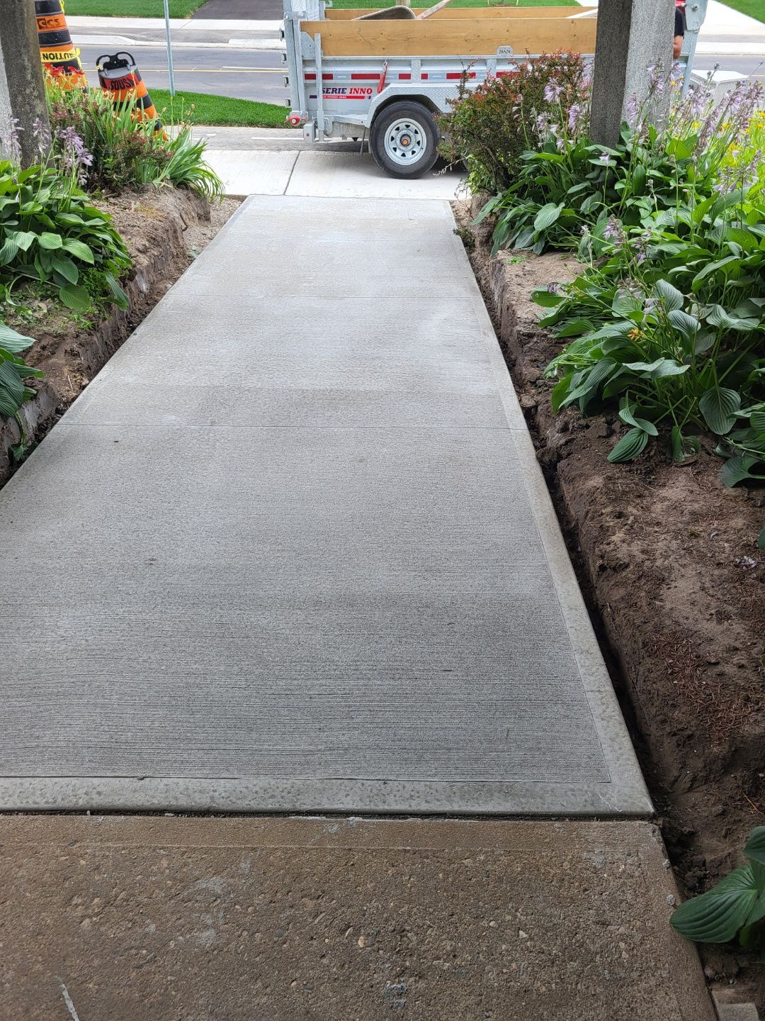 A concrete walkway with a trailer parked on the side of it.