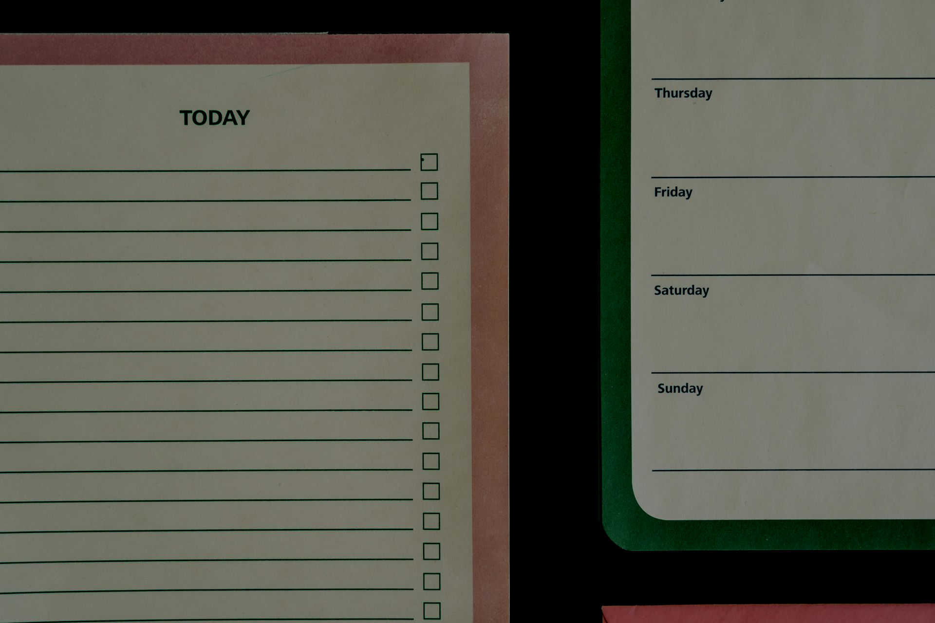 Pink and green planner boards against a black background. One board lists 