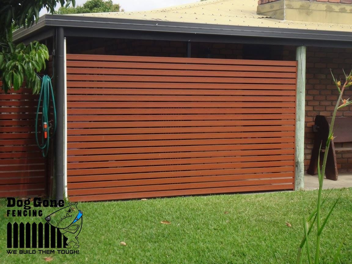 A Brown Aluminium Slated Fence In Front Of A House — Dog Gone Fencing in Paget, QLD