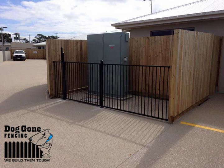 A Wooden Fence Surrounds A Building — Dog Gone Fencing in Paget, QLD