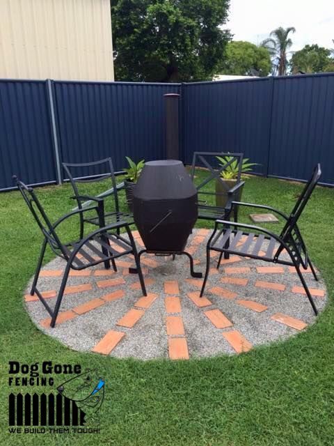A Patio With A Table And Chairs And A Fire Pit — Dog Gone Fencing in Paget, QLD
