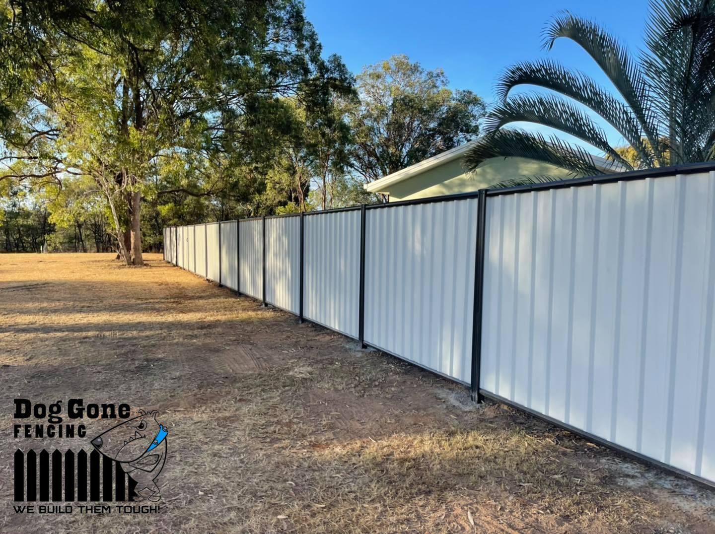 A White Fence With A Black Trim Is Sitting In The Middle Of A Field  — Dog Gone Fencing in Paget, QLD