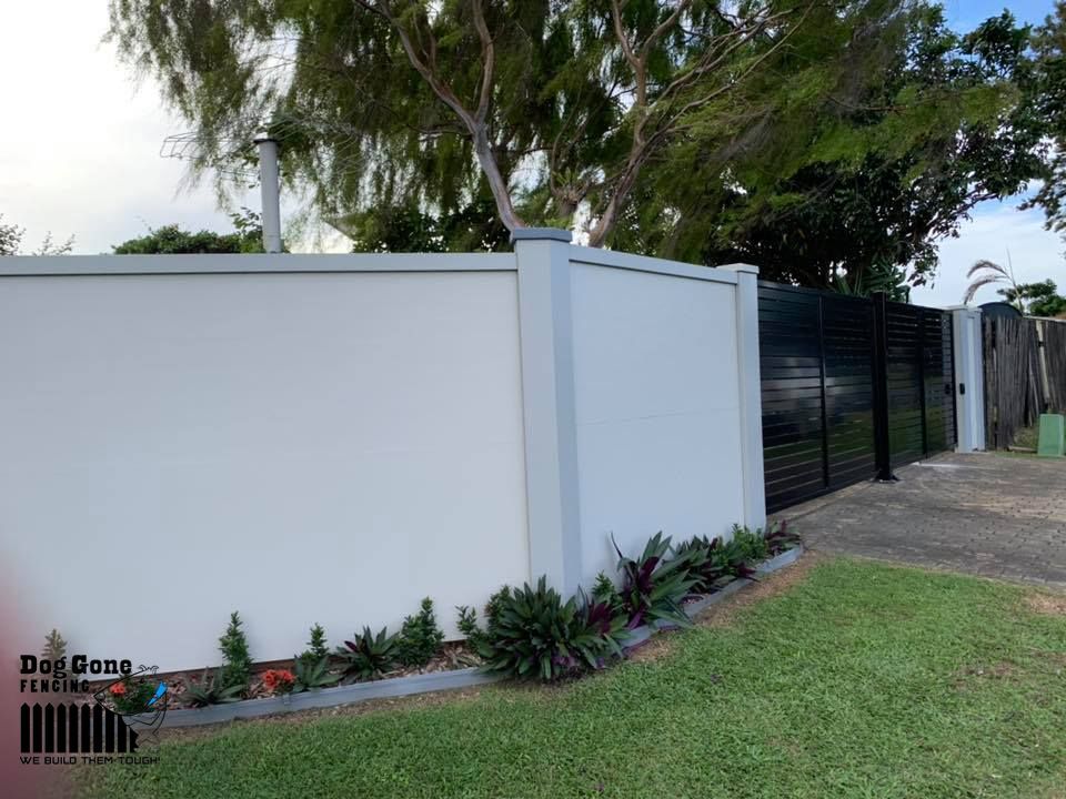 A White Fence With A Black Gate And Trees In The Background — Dog Gone Fencing in Paget, QLD