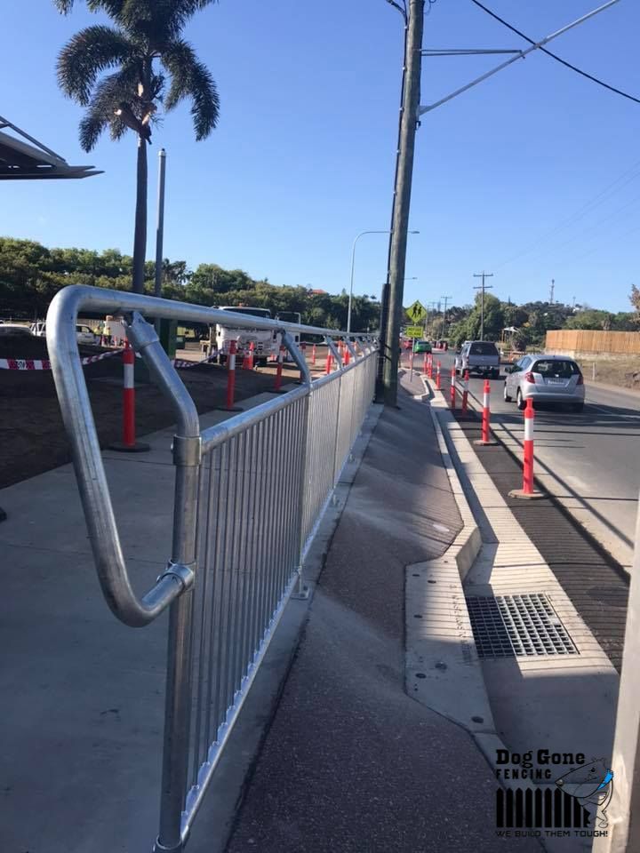 A Metal Fence Is Along The Side Of A Road — Dog Gone Fencing in Paget, QLD