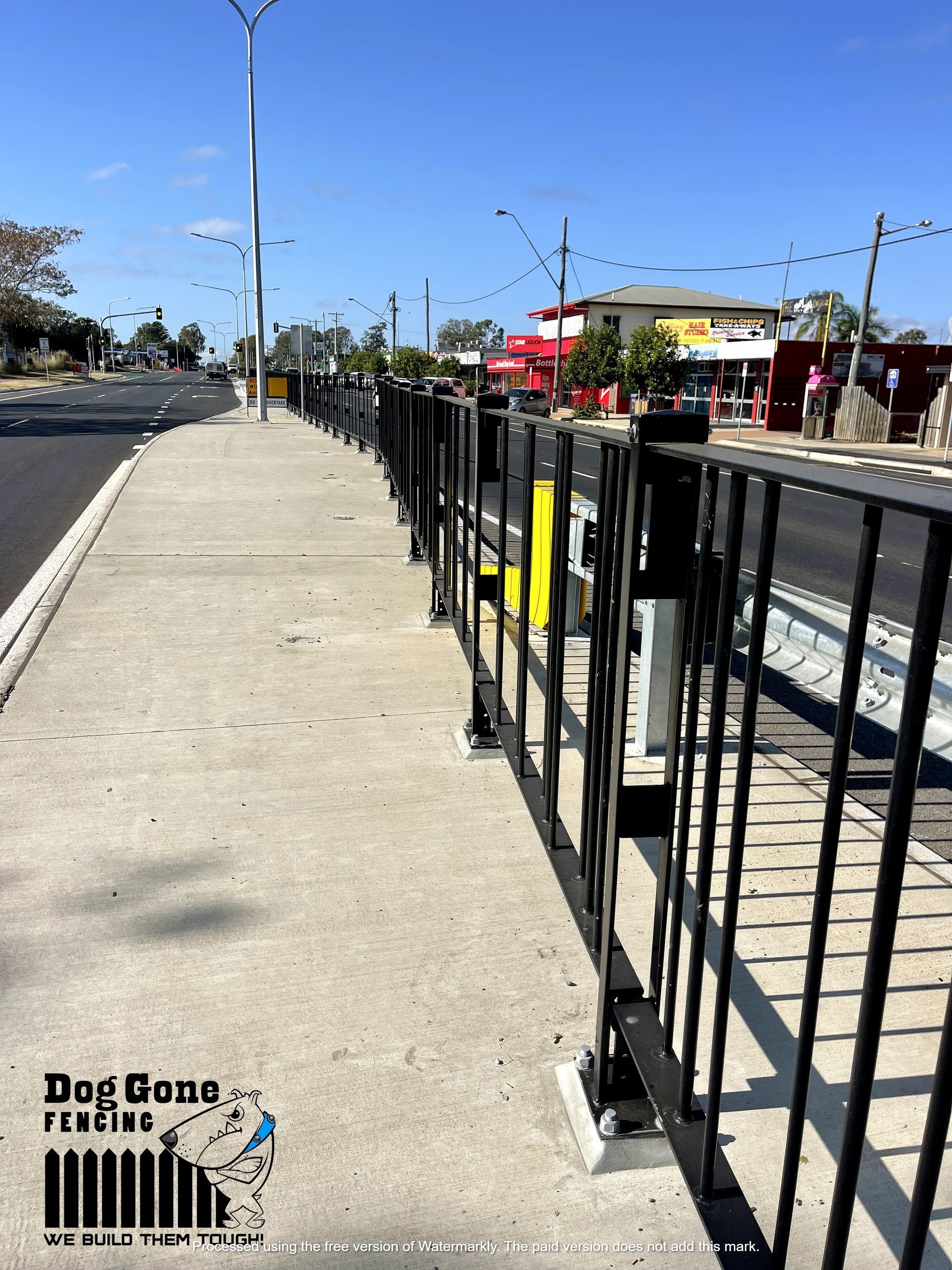 A Row Of Black Railings Along A Sidewalk Next To A Road — Dog Gone Fencing in Paget, QLD