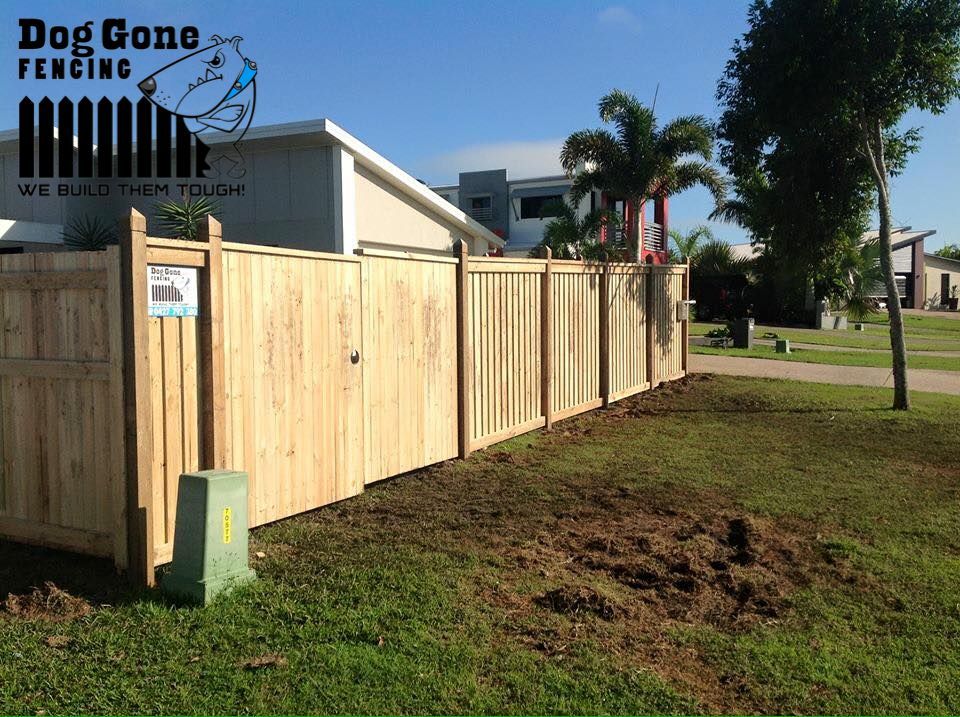 A Wooden Fence Surrounding A Residential House — Dog Gone Fencing in Paget, QLD
